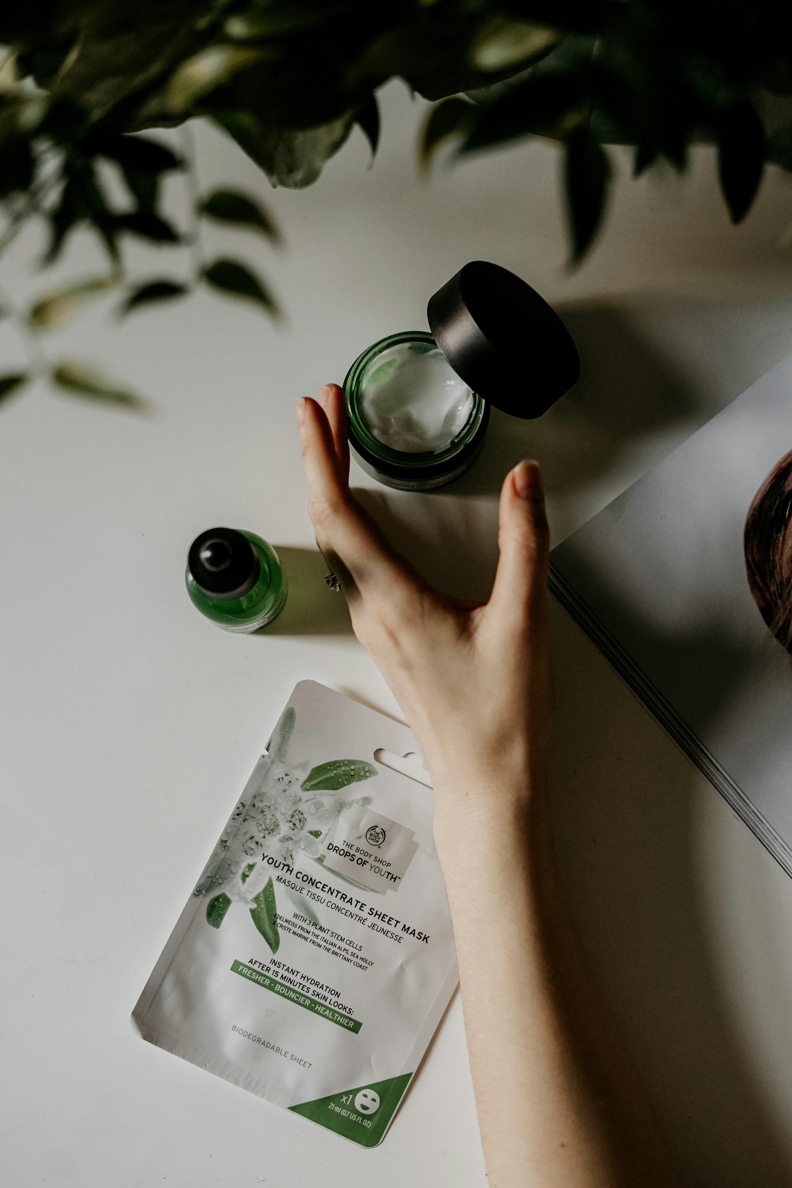 Hands applying skincare products on a bright surface